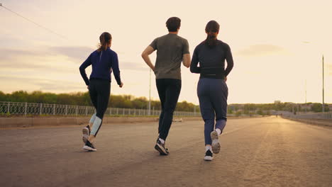 Sportliche-Menschen-Laufen-Im-Sommer-Morgens-Im-Freien,-Drei-Freunde-Oder-Professionelle-Läufer-Trainieren